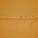 A close up of a gold polyester fabric with a hemmed edge.