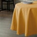 A yellow Intedge round tablecloth on a table.
