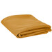 A folded gold table cover on a white background.