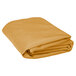 A folded gold table cover on a white background.