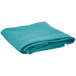 A folded teal round table cover on a white background.