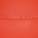An orange 100% polyester round table cover with hemmed edges.