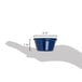 A hand holding a Carlisle cobalt blue smooth melamine ramekin.