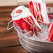 An American Metalcraft round galvanized metal tub filled with ice and beer cans on a table.