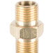 A brass threaded male connector on a metal surface.