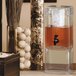 A Cal-Mil square acrylic beverage dispenser with an ice chamber filled with water and fruit.