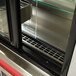 The glass door of a Delfield drop-in refrigerated air curtain merchandiser.