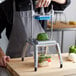 A man using a Nemco Easy Chopper III to slice vegetables.