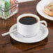 A Tuxton saucer with a cup of coffee and a plate of bread.