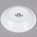A white Tuxton China saucer with a black Tuxton logo.
