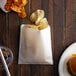 A Carnival King extra large sandwich bag with a burger and potato chips on a table.