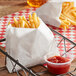 French fries in a Carnival King large paper bag with ketchup.