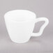 A close-up of a 10 Strawberry Street bright white porcelain cappuccino cup with a handle.