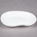 A 10 Strawberry Street bright white elliptical porcelain plate with a curved edge.