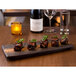 A rectangular stoneware slab with food on it on a table.