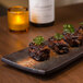 A rectangular stoneware slab with food on top.