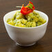 A 10 Strawberry Street bright white porcelain bowl filled with green vegetables on a table.