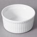 A white 10 Strawberry Street fluted porcelain ramekin on a gray surface.