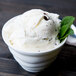 A 10 Strawberry Street bright white porcelain bowl of sorbet with mint leaves and a spoon.