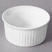 A white 10 Strawberry Street fluted ramekin on a gray surface.