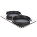 A metal tray holding two round black pans.