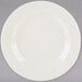 A Tuxton Reno ivory china plate with a wide rim on a gray background.