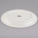 A white Tuxton oval china platter with a black narrow rim.