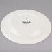 A Tuxton Reno ivory china plate with black text reading "Tuxton" on it.