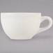 A close-up of a white china cup with a handle.