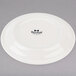 An ivory Tuxton Nevada narrow rim china plate with black text that says "Tuxton"