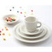 A white Tuxton Nevada plate with a bowl and a cup of candy on it.