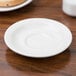 A white Tuxton Nevada saucer on a table.