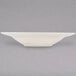 A white Tuxton pasta bowl on a gray surface.