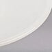 A close up of a Tuxton Reno white saucer with a circular rim.