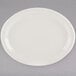 A white Tuxton oval china platter with a narrow rim on a gray surface.