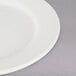 A Tuxton Reno ivory wide rim china plate on a white background.