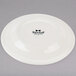 A Tuxton Reno ivory china plate with black text reading "Tuxton" on it.