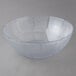 A Carlisle clear polycarbonate bowl with a scalloped edge.