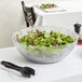 A clear Carlisle Petal Mist bowl filled with salad on a table.