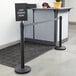 A black Lancaster Table & Seating sign that says "Line Forms Here" with clear covers.