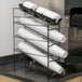 A San Jamar Wireworks countertop organizer with white plastic cups in it.