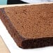 A square cake with a level top on a cutting board.