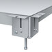 A close-up of a metal table top with two bolts.