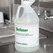 A white jug of Advantage Chemicals Delimer on a counter.