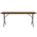 A brown rectangular Correll folding table with a medium oak wooden top.