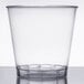 A clear Fineline Savvi Serve hard plastic shot glass on a white table.