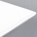 A close-up of a CAC Citysquare bright white square porcelain bowl.