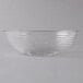 A clear Cambro Camwear round ribbed bowl on a white surface.