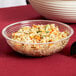 A close up of a Cambro clear ribbed bowl filled with rice and vegetables on a table.