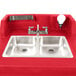 A red Cambro CamKiosk portable hand sink with two sinks and two faucets.